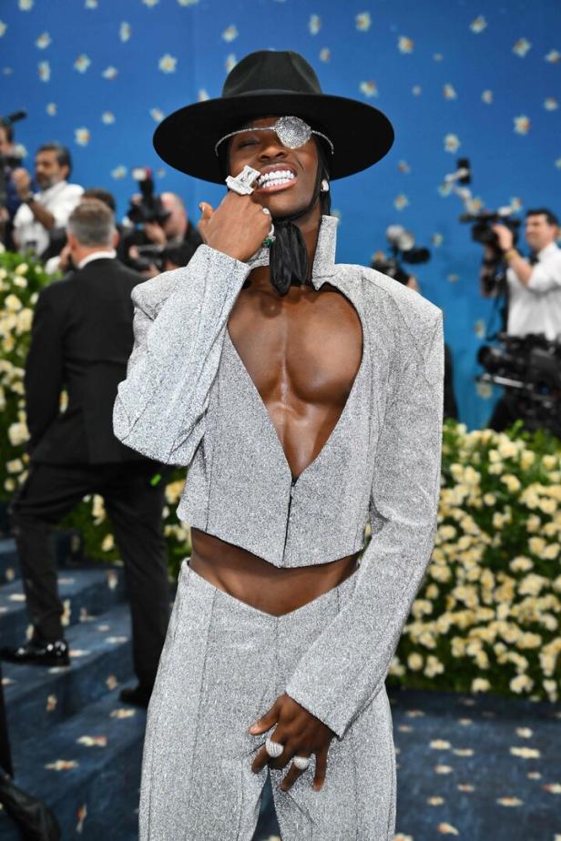 Lil Nas X in einem silbernen Glitzeranzug und mit Augenklappe auf dem roten Teppich der Met Gala.