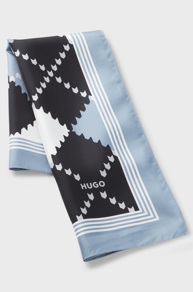 Ein blau-schwarz-weißer Seidenschal mit dem HUGO-Logo.