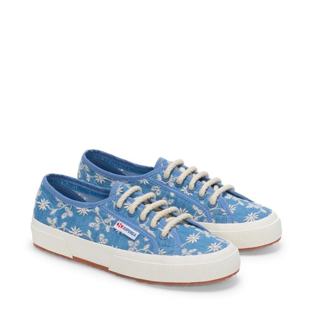 Zwei blaue Superga-Sneakers mit Blumenmuster und weißen Schnürsenkeln stehen auf einem weißen Hintergrund.