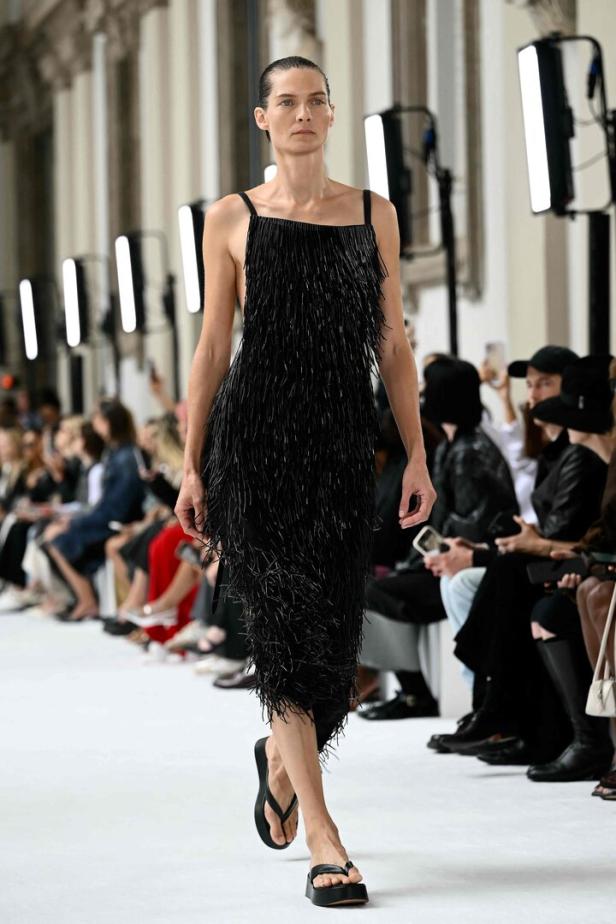 Ein Model präsentiert ein schwarzes Fransenkleid von Sportmax auf einer Mailänder Modenschau.