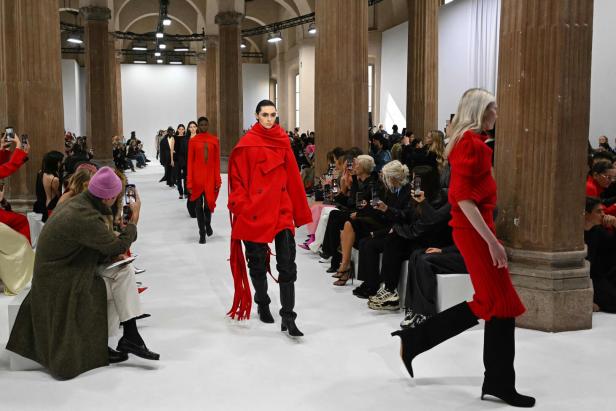 Models präsentieren rote Kleidung auf dem Laufsteg einer Sportmax-Modenschau in Italien.