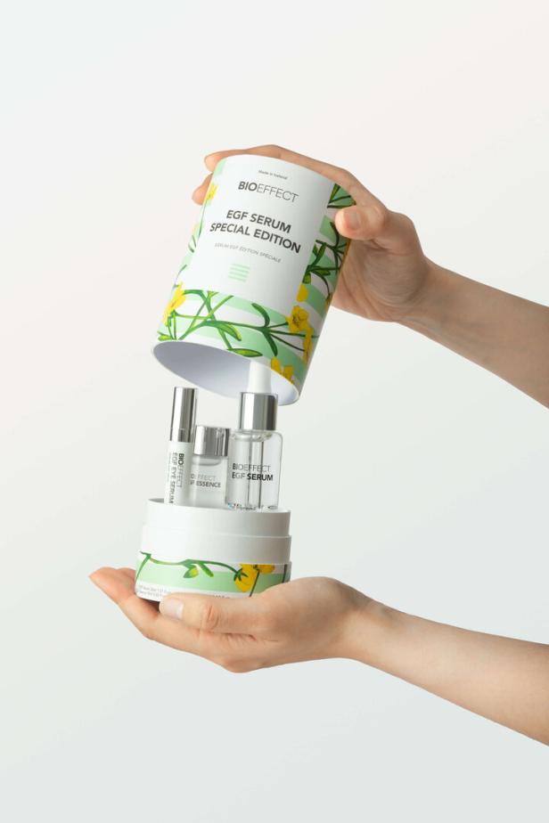 Eine Hand öffnet eine Geschenkverpackung mit Bioeffect EGF Seren.