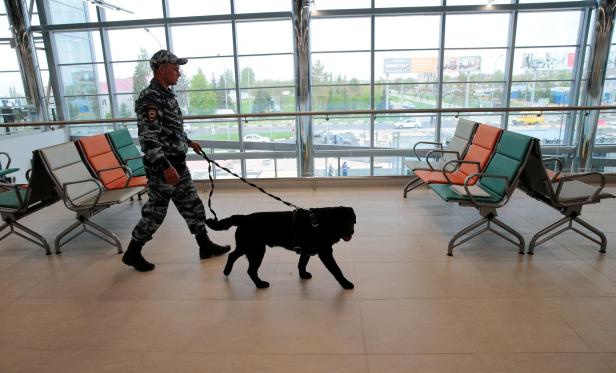 FILE PHOTO: A policeman with a dog walks at Volgograd International Airport FILE PHOTO: A policeman with a dog walks at Volgograd International Airport