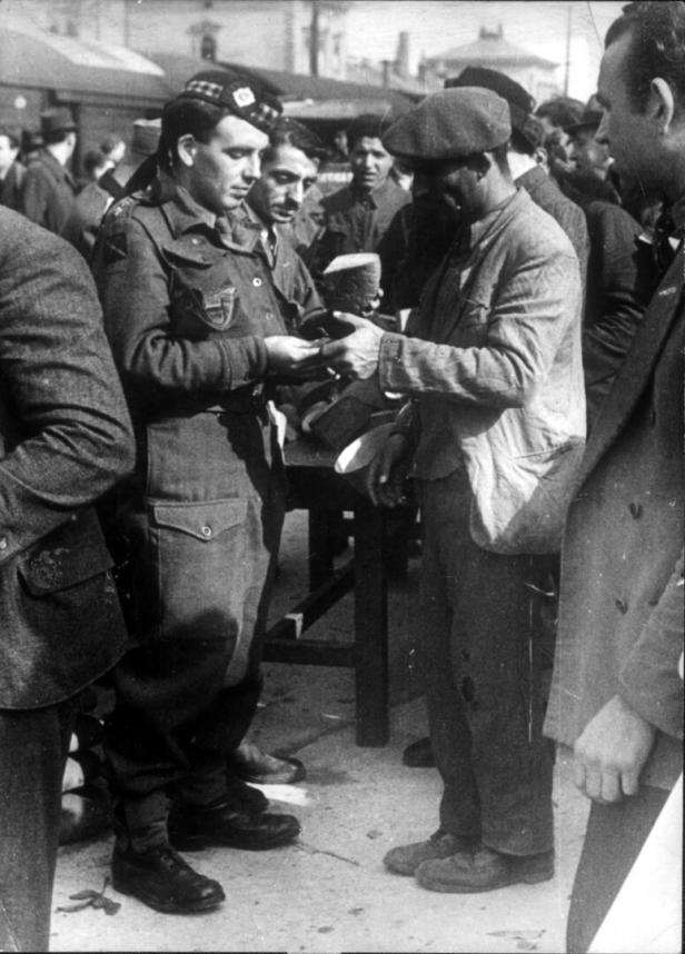Unmittelbar nach dem Krieg war die Not groß. Dieser Arbeiter wird von einem Soldat mit einem Viertel Brot bezahlt.