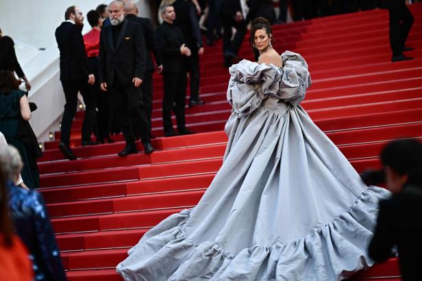 Eine Frau in einem auffälligen, silbernen Kleid auf dem roten Teppich in Cannes.