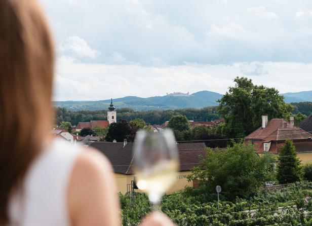 Eine Frau mit einem Weinglas, das sie elegant in der Hand hält.