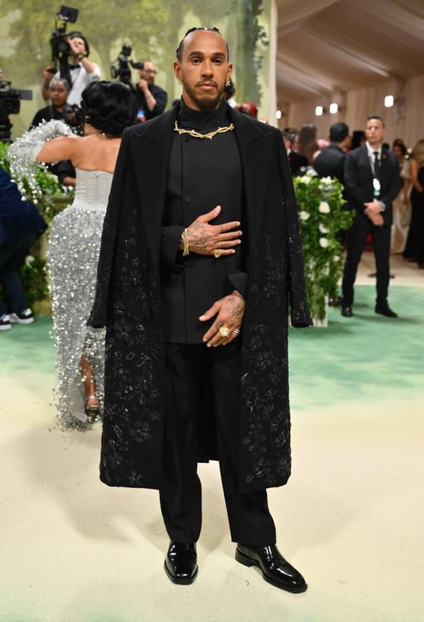 Lewis Hamilton in einem schwarzen Outfit und einem goldenen Halsband auf der Met Gala.