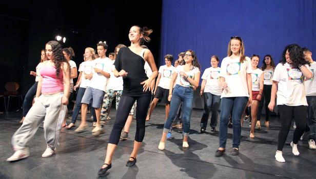 Eine Gruppe junger Leute tanzt auf einer Bühne.