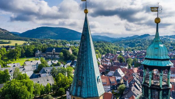 Blick von der Kirchturmspitze auf die Stadt Goslar, mit historischen Gebäuden und grüner Landschaft im Hintergrund.