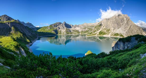 Der türkisblaue Lünersee liegt eingebettet in einer Berglandschaft.