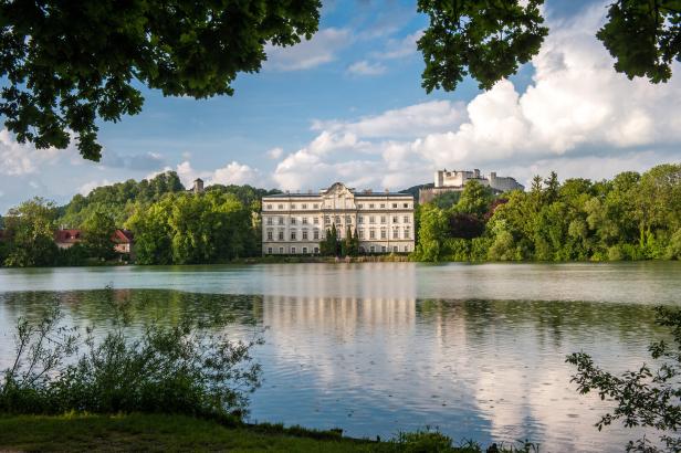 Schloss Leopoldskron spiegelt sich im Leopoldskroner Weiher in Salzburg.