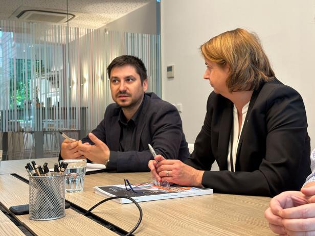 Auf dem Bild sind ein Mann und eine Frau in einer Interviewsituation abgebildet, sie sprechen miteinander.