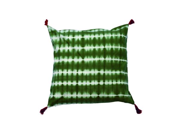Ein quadratisches Kissen mit einem Batikmuster in Grün und Weiß und roten Quasten an den Ecken.