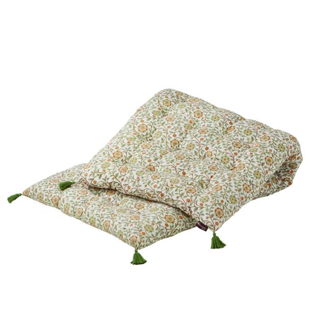 Eine gesteppte Spielmatte mit Blumenmuster und grünen Quasten an den Ecken.