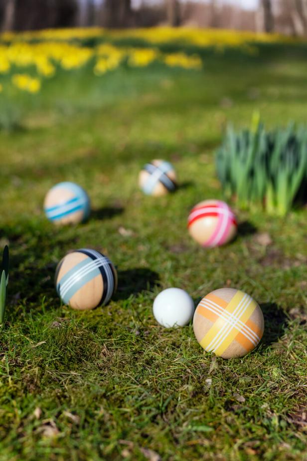 Mehrere Boccia-Kugeln liegen auf einer grünen Wiese.