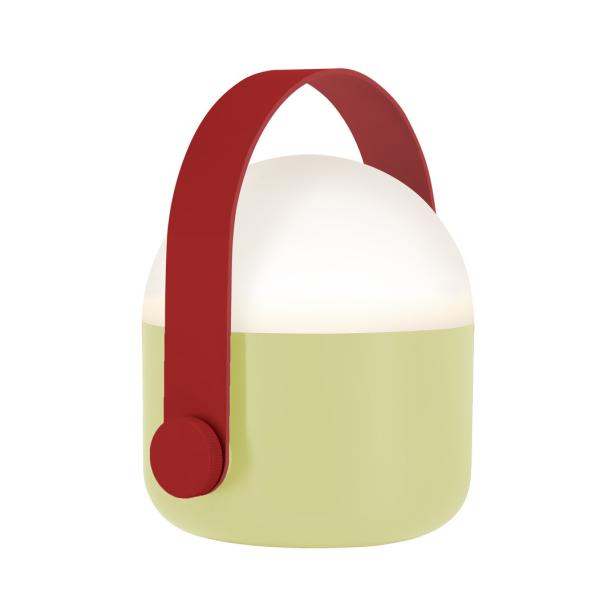 Eine tragbare, grüne Lampe mit einem roten Griff leuchtet.