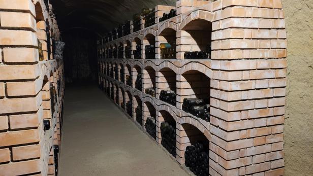 Weinregale gefüllt mit Weinflaschen in einem Weinkeller.