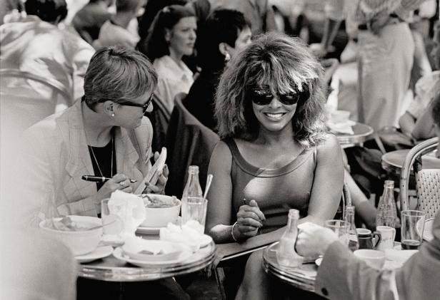 Tina Turner sitzt mit einer Begleiterin in einem Café.