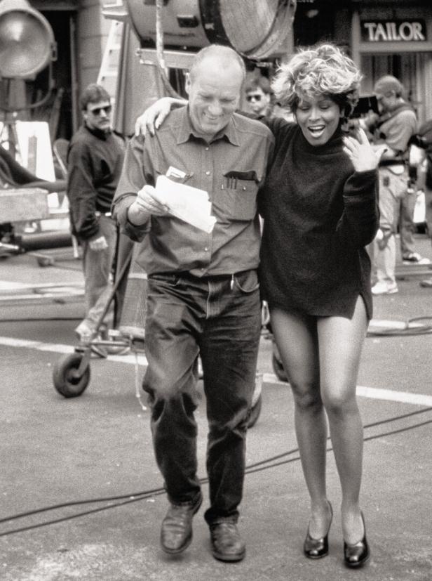 Tina Turner mit einem Mann am Set des Films „Mad Max: Jenseits der Donnerkuppel“.