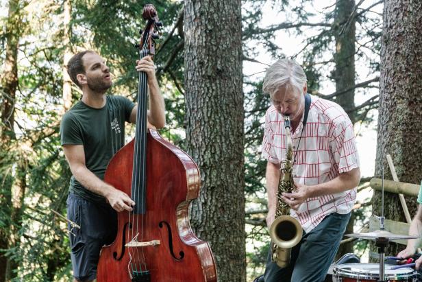 Zwei Musiker spielen im Wald Kontrabass und Saxophon.