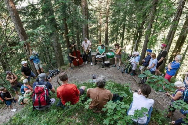 Eine Jazzband spielt für ein Publikum im Wald.