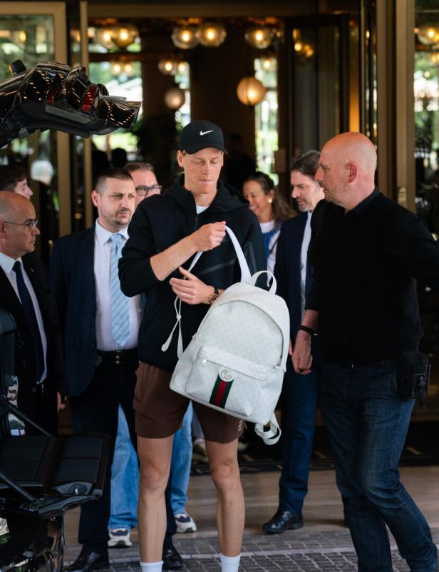 Jannik Sinner verlässt ein Gebäude mit einem weißen Gucci-Rucksack.