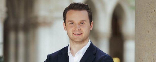 Harald Zierfuß von der ÖVP Wien posiert mit verschränkten Armen vor einem Gebäude.