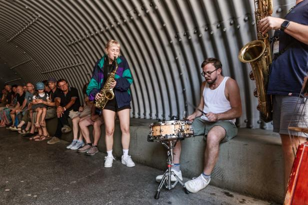 Eine Saxophonistin und ein Schlagzeuger spielen vor Publikum beim Jazzfestival Saalfelden 2024.
