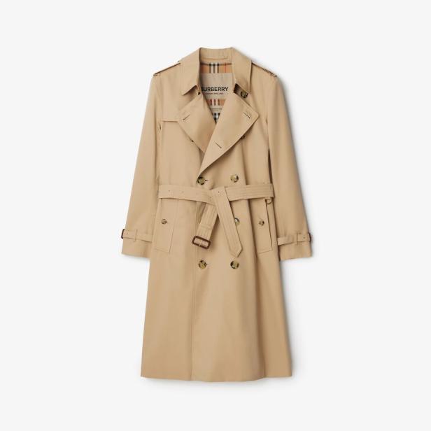 Ein beiger Trenchcoat der Marke Burberry mit Gürtel vor einem weißen Hintergrund.