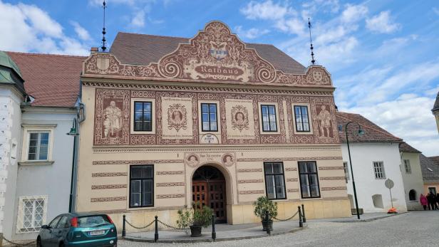 Ein altes Haus mit Verzierungen und einem großen Tor als Eingang.