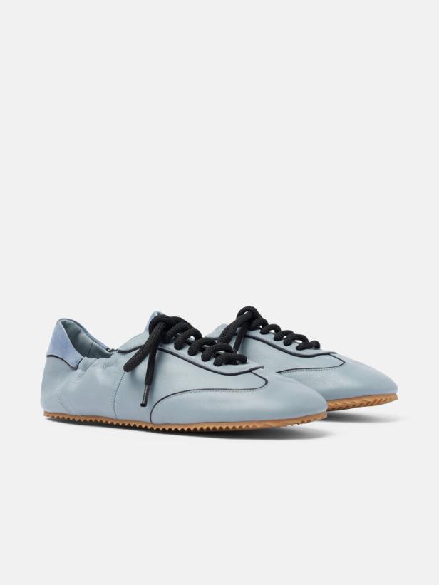 Ein Paar hellblaue Ledersneakers mit schwarzen Schnürsenkeln stehen auf einem weißen Hintergrund.