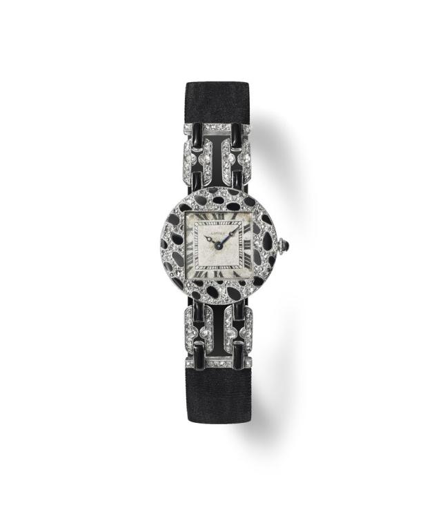 Eine elegante Damenuhr mit Diamanten und schwarzem Armband liegt auf einem weißen Hintergrund.
