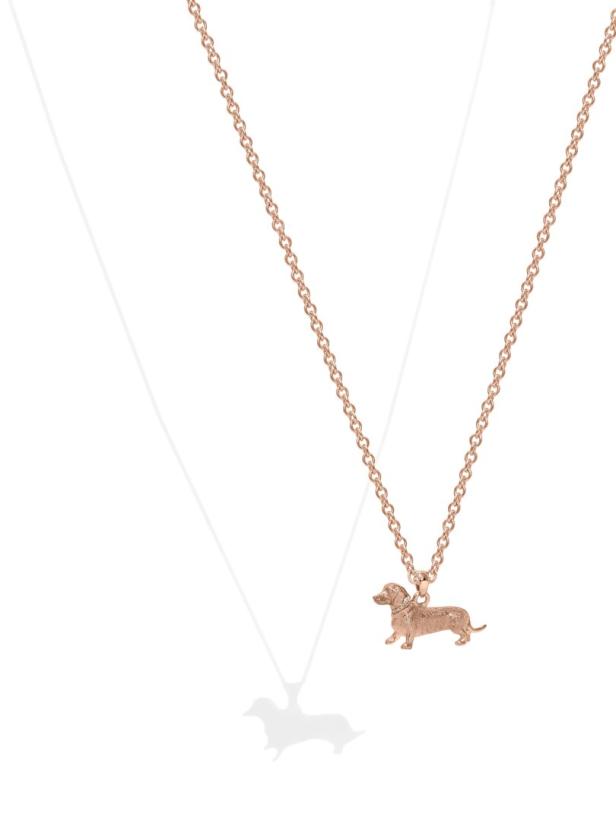 Eine goldene Halskette mit einem Dackel-Anhänger.