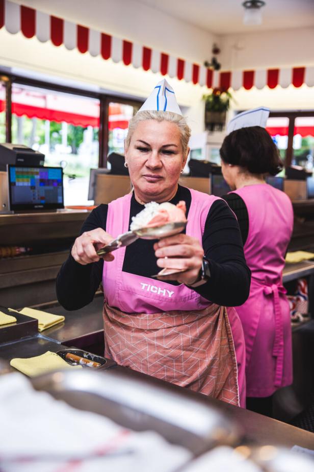 Eine Verkäuferin von Tichy bereitet Eis zu.