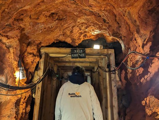 Eine Person betritt einen Stollen mit der Aufschrift „Salz Grenze“.
