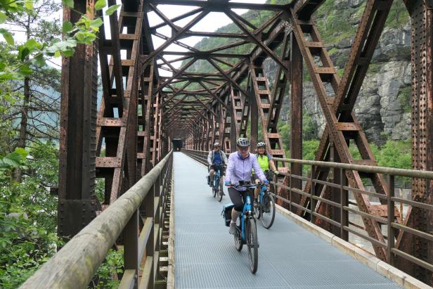 radfahrer am alpe adria radweg über ein alte bahntrasse