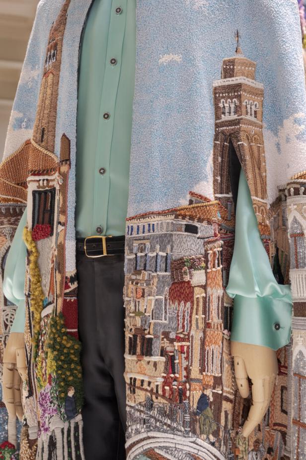Ein bestickter Mantel mit einer Darstellung von Venedig wird auf einer Schneiderpuppe präsentiert.