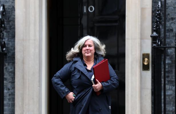Eine Frau verlässt Downing Street mit einer roten Mappe in der Hand.