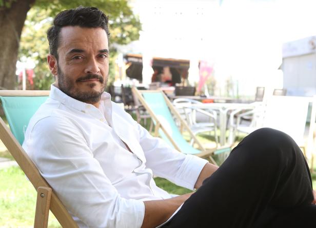 Giovanni Zarrella sitzt entspannt in einem Liegestuhl im Freien.