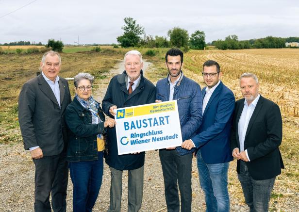 Eine Gruppe von Personen hält ein Schild mit der Aufschrift „Baustart Ringschluss Wiener Neustadt“.