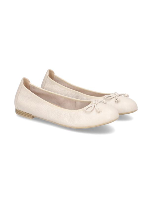 Ein Paar cremefarbene Ballerinas mit Schleife stehen auf einem weißen Hintergrund.