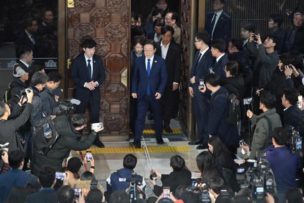 SKOREA-POLITICS-CONFLICT Lee Jae-myung verlässt ein Gebäude, umringt von Reportern und Sicherheitsleuten.