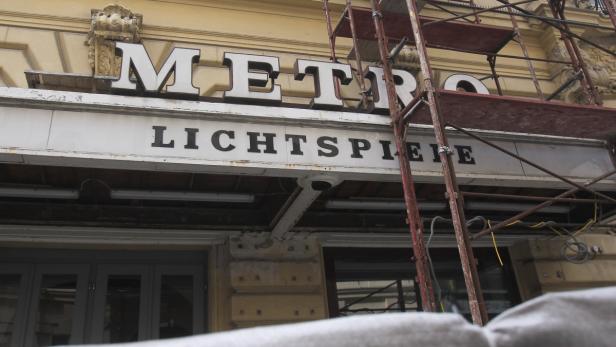 Das Schild „Metro Lichtspiele“ an einem Gebäude unter einem Baugerüst.