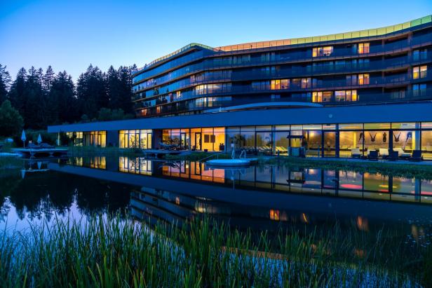 Ein Spa-Hotel bei Nacht. Davor ist ein Teich zu sehen. 