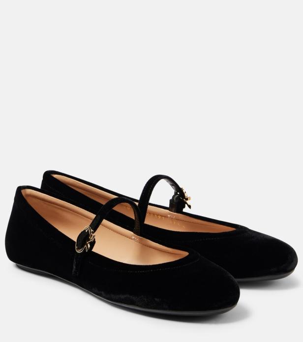 Zwei schwarze Samt-Ballerinas mit Riemchen und goldenen Schnallen stehen nebeneinander.