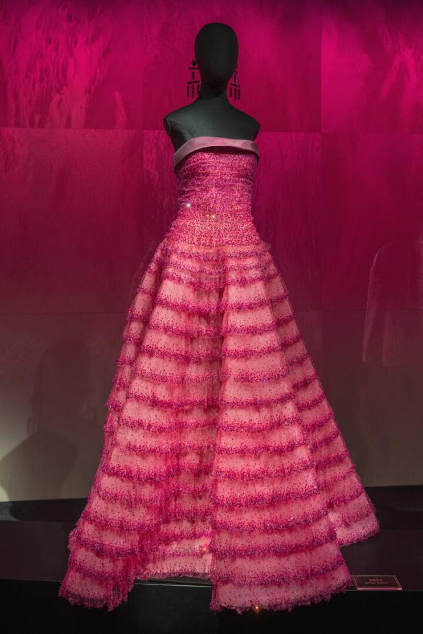 Ein rosa, trägerloses Abendkleid mit Rüschen und Pailletten auf einer Schaufensterpuppe.