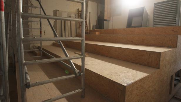 Eine Baustelle mit einer provisorischen Treppe aus Holz und einem Gerüst.