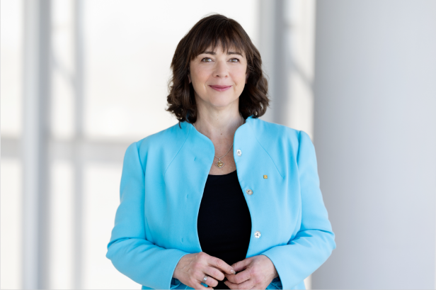 Eine brünette Frau in einem hellblauen Blazer 