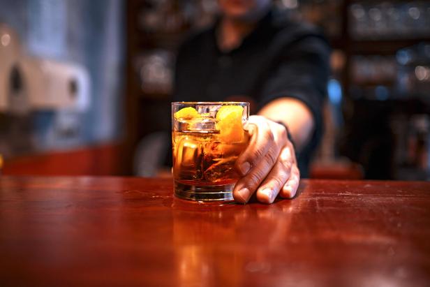 Bartender serving a cocktail drink on a bar counter