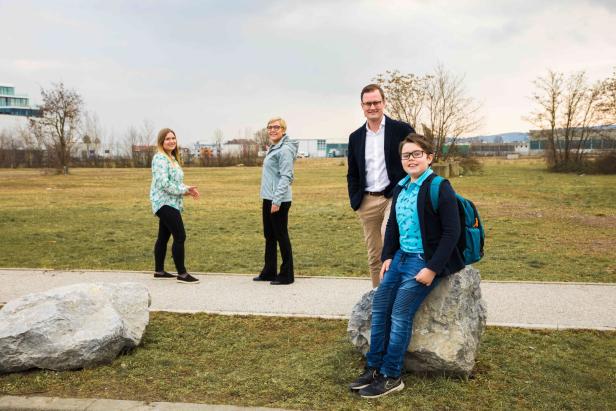 Eine Familie posiert in einem Park für ein Foto.